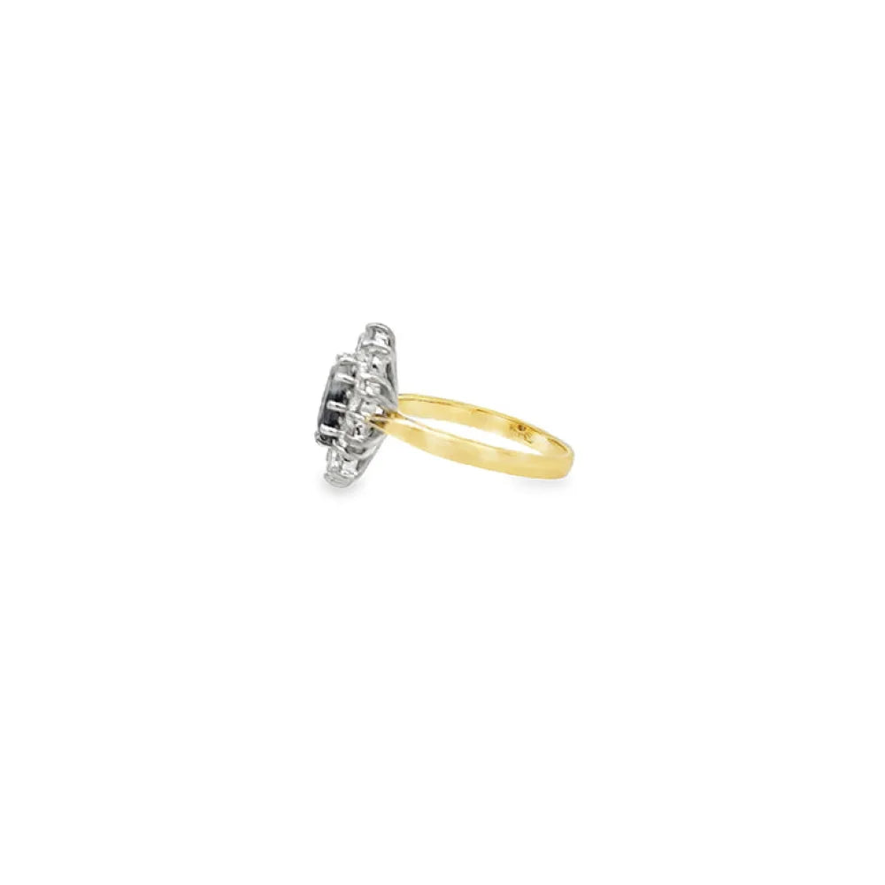 Sapphire and diamond cluster ring in 18ct yellow gold, featuring an oval sapphire and round brilliant cut diamonds.