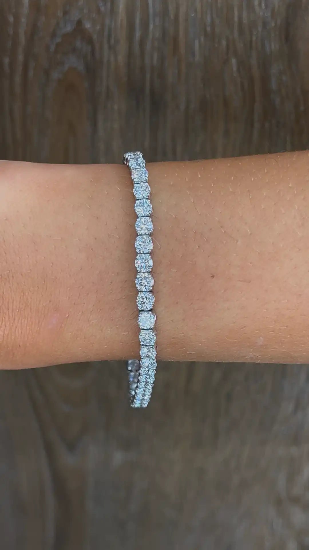 platinum tennis bracelet on a wrist with a blurred background