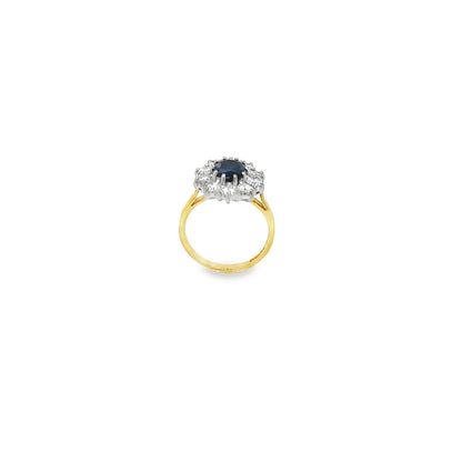 Sapphire and diamond cluster ring in 18ct yellow gold with oval sapphire and round brilliant cut diamonds.