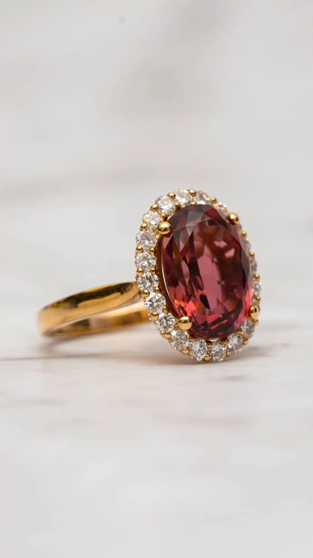 yellow gold ring with a large tourmaline gemstone on a light background
